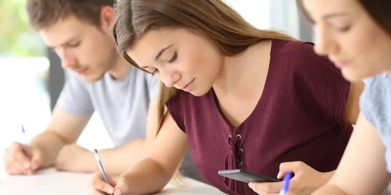 Fille en train d'utiliser son téléphone en classe